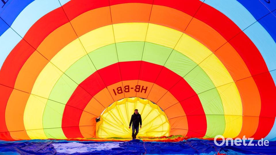 Ein Teammitglied überprüft seinen Heißluftballon vor dem Start während des 46. Internationalen Heißluftballon-Festivals in Chateau-d'Oex. Bild: Cyril Zingaro/KEYSTONE/dpa