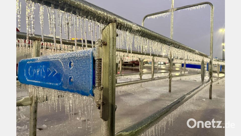 Eiszapfen hängen an einem Geländer während eines Wintersturms auf einem Parkplatz. Bild: John Raby/AP/dpa