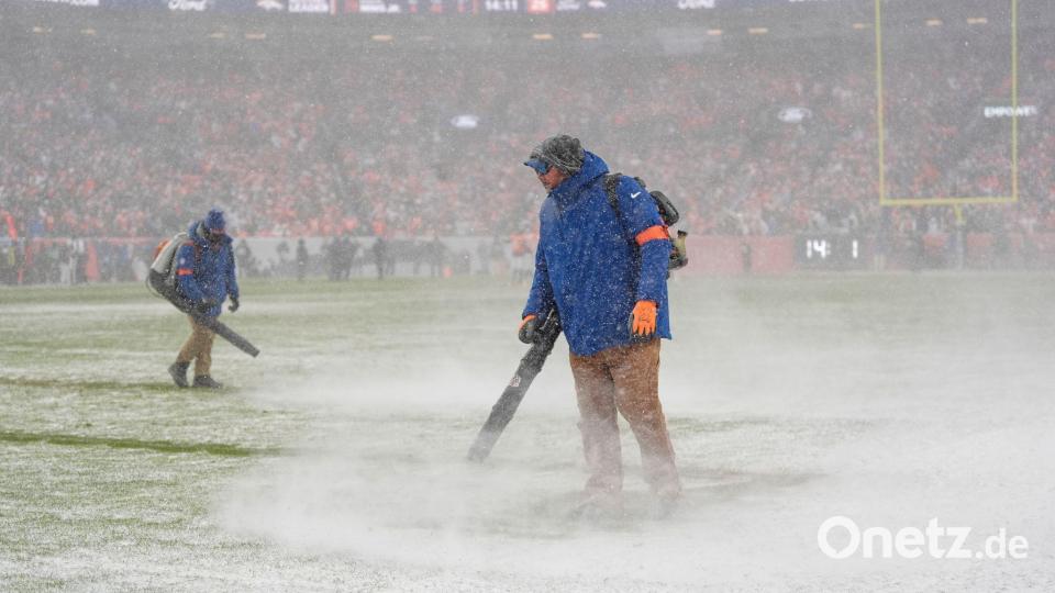Greenkeeper der Denver Broncos blasen den Schnee von den Yard-Linien. Bild: Ashley Landis/AP/dpa