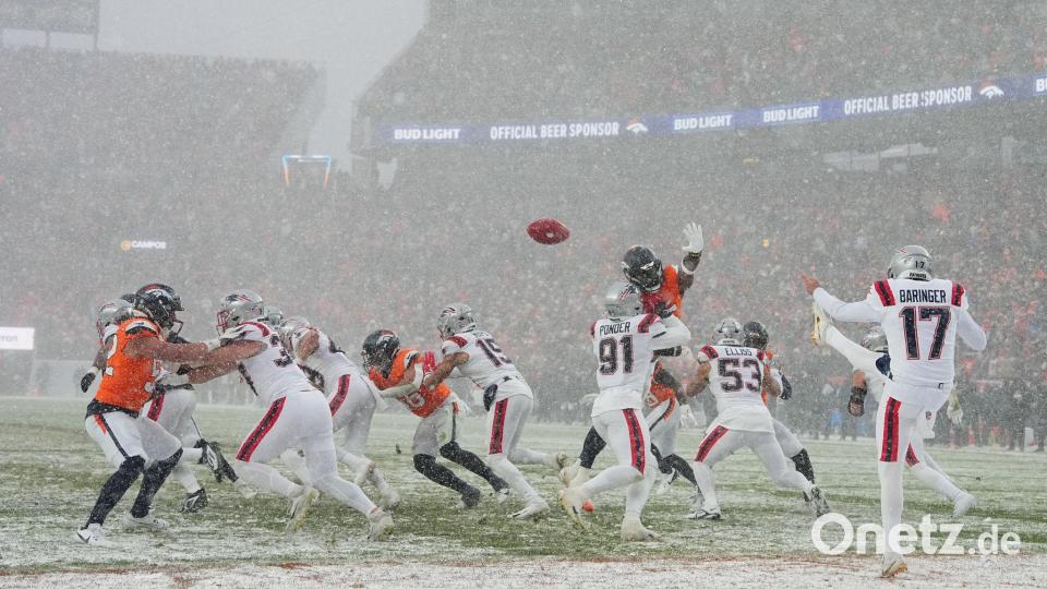 New England Patriots Punter Bryce Baringer (M) bei Schneefall in Aktion. Bild: Garrett W. Ellwood/AP/dpa