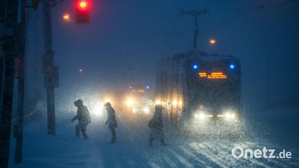Menschen gehen bei Schneefall durch die Innenstadt von Toronto. Bild: Cole Burstona/The Canadian Press/dpa