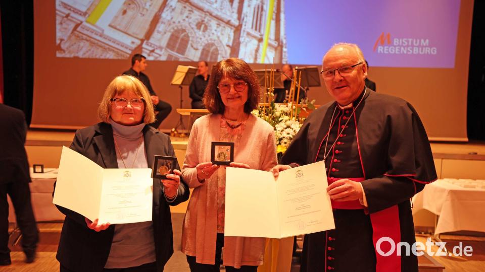Margret Lukas-Fuchs (links) aus Moosbach und Christine Schwab (Mitte) aus Luhe-Wildenau erhalten aus der Hand des Diözesanbischofs Dr. Rudolf Voderholzer die Wolfgangsmedaille. Bild: Jakob Schötz