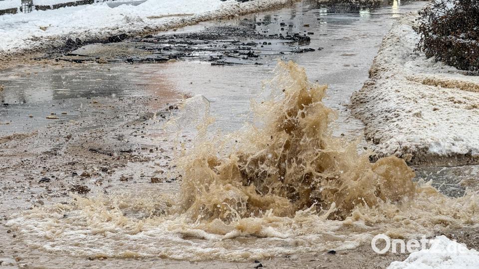 Minutenlang strömte das Wasser schwallartig aus dem Boden und überschwemmte Teile der Bahnhofstraße. Im Hintergrund ist zu sehen, dass der Asphalt auf mehreren Metern Länge aufgebrochen ist. Bild: Petra Hartl