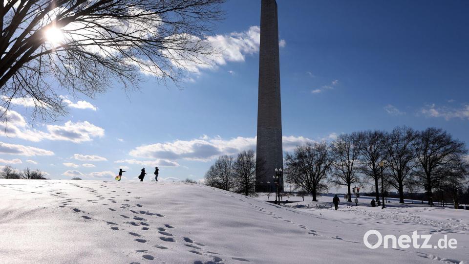 Menschen spazieren im Schnee auf der National Mall. Bild: Gent Shkullaku/ZUMA Press Wire/dpa