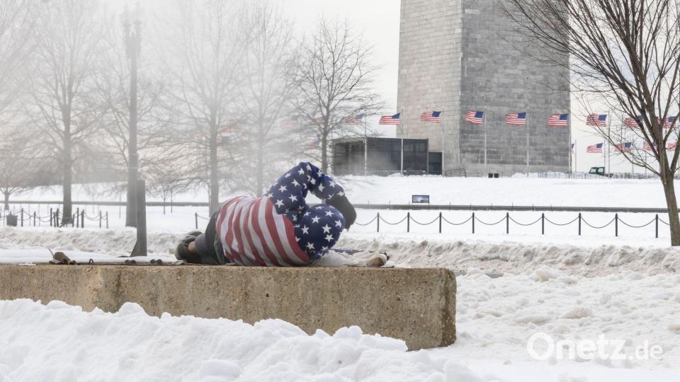 Ein Obdachloser ruht sich nach einem schweren Wintersturm in der Nähe des Washington Monuments auf. Bild: Mehmet Eser/SOPA Images via ZUMA Press Wire/dpa