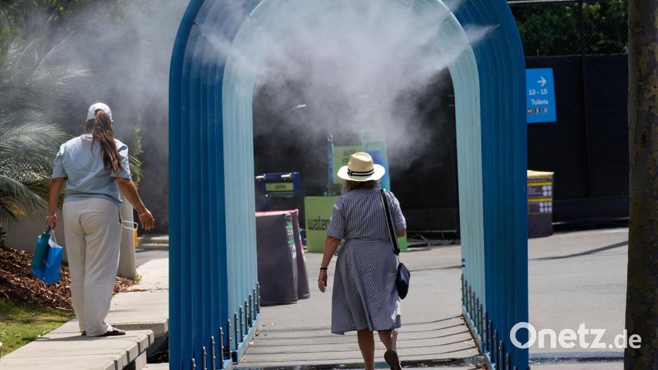 Fans laufen durch Wassernebel bei den Australian Open. Bild: Dar Yasin/AP/dpa