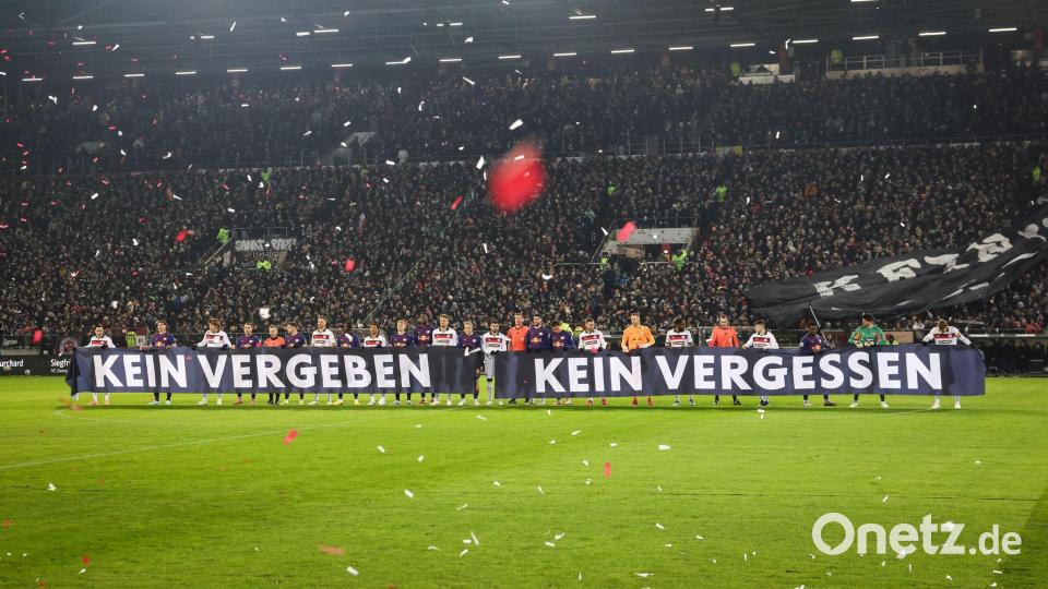Spieler beider Teams halten vor Spielbeginn ein Banner anlässlich das Holocaust-Gedenktags hoch. Bild: Christian Charisius/dpa