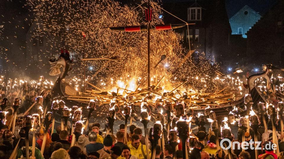 Mitglieder vom Jarl Squad zünden eine Galeere in Lerwick auf den Shetlandinseln während des Up Helly Aa-Festivals an. Bild: Jane Barlow/PA Wire/dpa