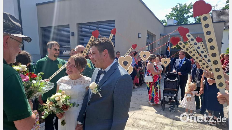 Schützenmeister Josef Robl (links) empfängt das Brautpaar mit herzlichen Worten. Die Mitglieder der Hubertus-Schützen hielten Zielscheiben in Herzform im Spalier in die Höhe. Bild: ise