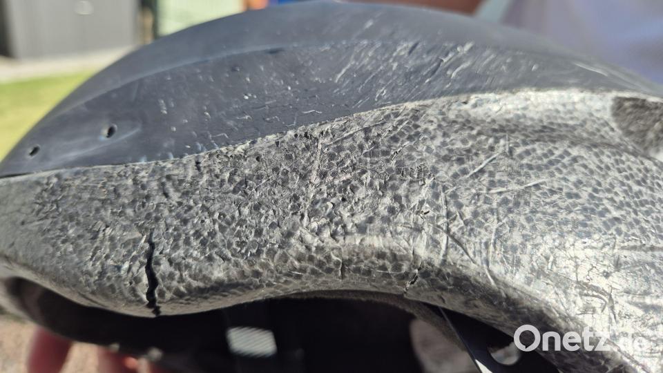 Der Riss und die Spuren, die der Aufprall auf dem Asphalt hinterlassen hat, sind auf dem Fahrradhelm deutlich zu erkennen. Bild: Lowak