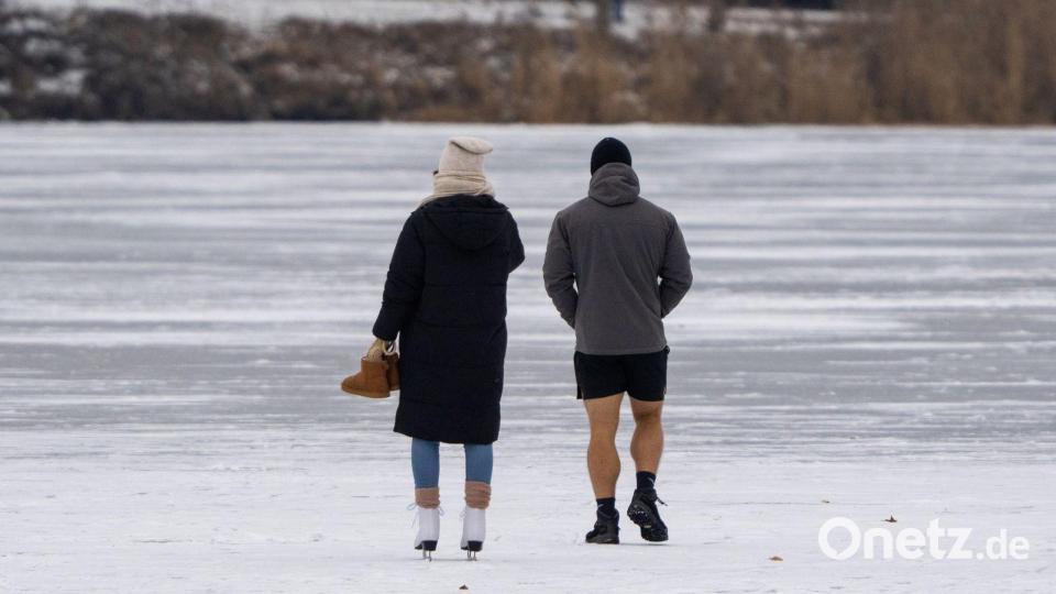 Unten kurz bei Minusgraden: Menschen laufen auf einem zugefrorenen See in Potsdam übers Eis. Bild: Georg-Friedrich Moritz/dpa