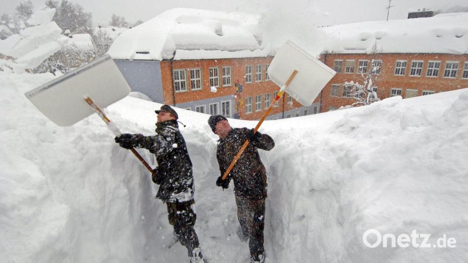 In Zwiesel mussten 2006 Bundeswehrsoldaten Schnee vom Dach einer Schule schaufeln. (Archivbild) Bild: Armin Weigel/dpa