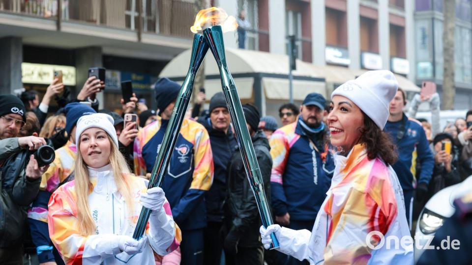 Olympische Winterspiele: Athletinnen beim Fackellauf mit der Flamme in Cortina D'ampezzo. Bild: Luciano Maria Bisi/LiveMedia-IPA/ZUMA Press Wire/dpa