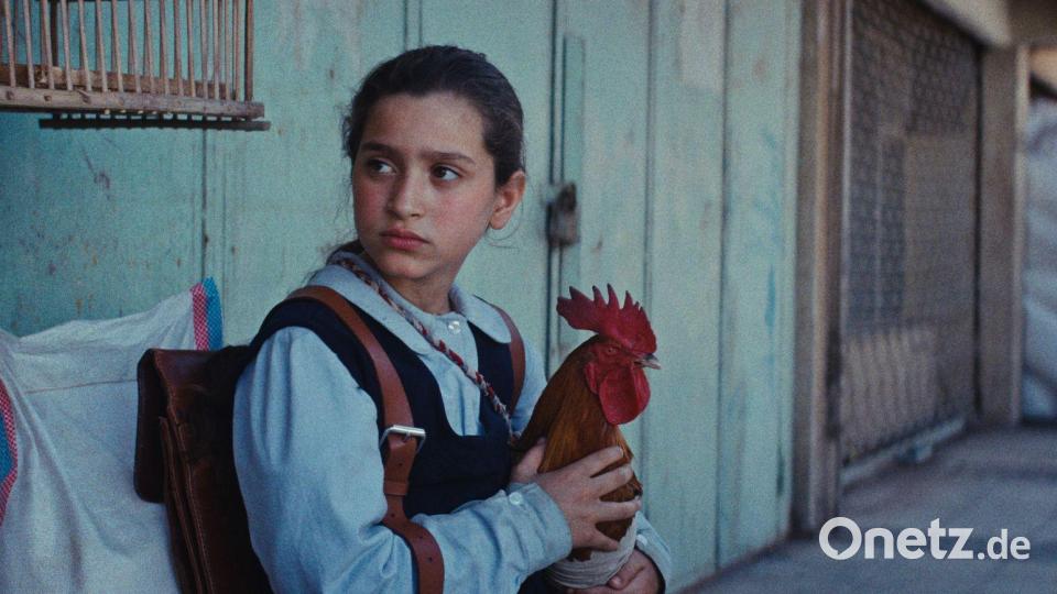 Lamia (Baneen Ahmed Nayyef) mit Hahn Hindi in einer Szene des Films „Ein Kuchen für den Präsidenten“ (undatierte Filmszene). Bild: -/Vuelta Germany/dpa