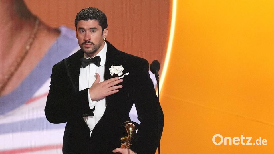 Bad Bunny nimmt den Preis für das Album des Jahres für „DeBÍ TiRAR MáS FOToS“ bei den Grammy Awards entgegen - und zeigt dabei, wo seine Heimat Puerto Rico liegt. (Archivbild) Bild: Chris Pizzello/Invision/AP/dpa
