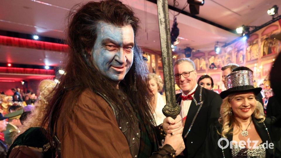 Markus Söder (l, CSU), Ministerpräsident von Bayern, nimmt als "Braveheart" an der BR-Livesendung "Fastnacht in Franken" in den Mainfrankensälen teil. Bild: Daniel Löb/dpa