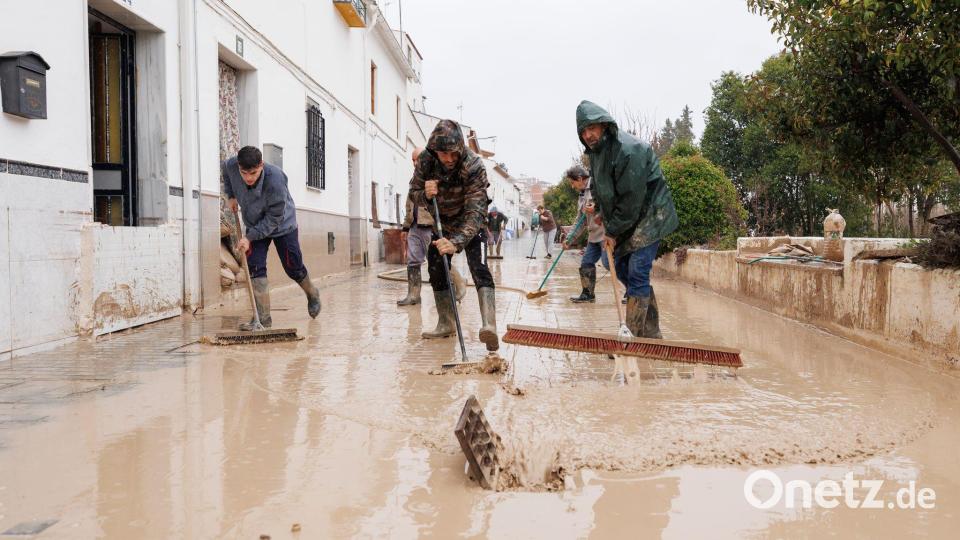 Menschen im südspanischen Andalusien reinigen Straßen nach dem Sturmtief "Leonardo". Am Samstag folgte schon das nächste Atlantiktief "Marta". Bild: Álex Cámara/EUROPA PRESS/dpa