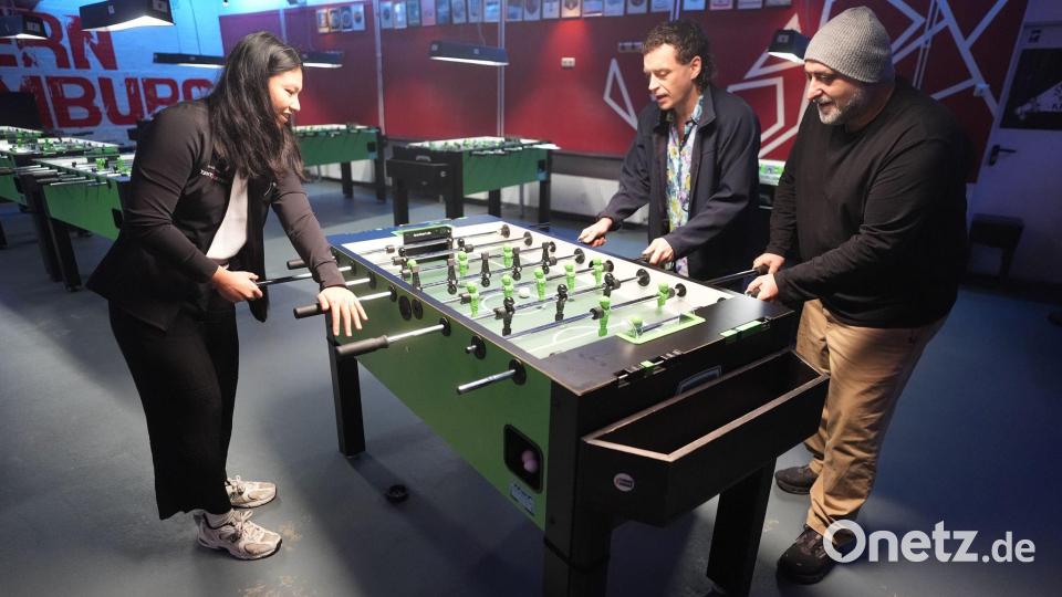 Tischkicker-Weltmeisterin Linh Tran zeigt ihr Können den beiden Schauspielern. Bild: Marcus Brandt/dpa