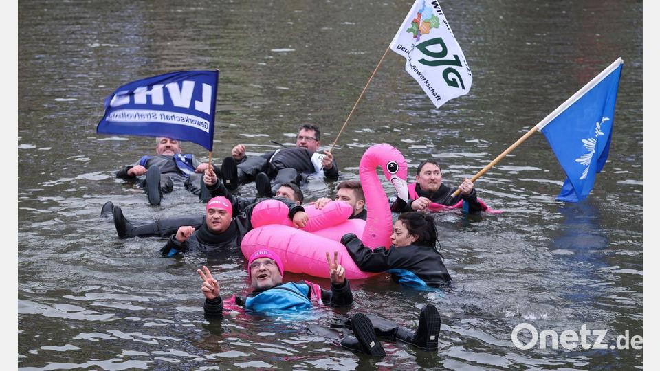 Unter dem Motto "Wir gehen baden, damit der Norden nicht absäuft" schwimmen Teilnehmer beim Warnstreik im öffentlichen Dienst in Hamburg. Bild: Christian Charisius/dpa
