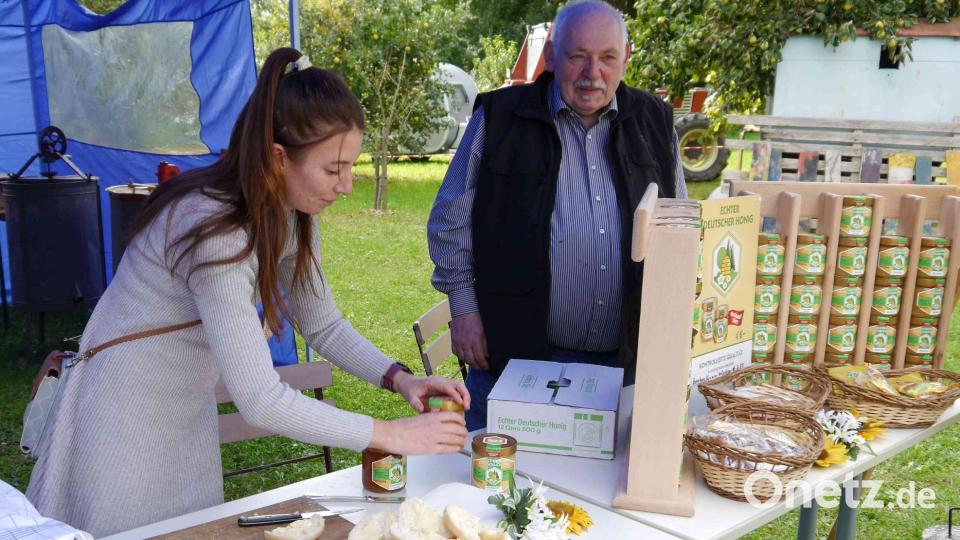 Imker Reinhold Ziegler (rechts) zeigte Produkte und informierte über die Bedeutung der Bienen für unsere Umwelt. Dazu gab es kostenlos Honigsemmeln. Bild: Heimat- und Trachtenverein/Josef Leipold/exb