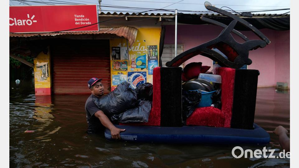 Bewohner bergen Hab und Gut aus überfluteten Häusern in der kolumbianischen Stadt Monteria, nachdem der Fluss Sinu durch Regen über die Ufer getreten ist. Bild: Fernando Vergara/AP/dpa