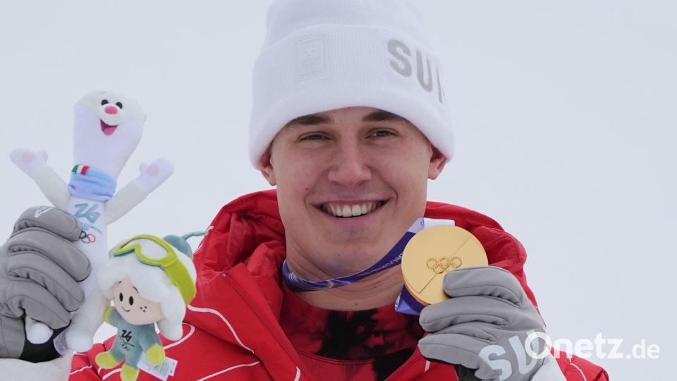 Franjo von Allmen zeigt eine seiner drei olympischen Goldmedaillen. Bild: Rebecca Blackwell/AP/dpa