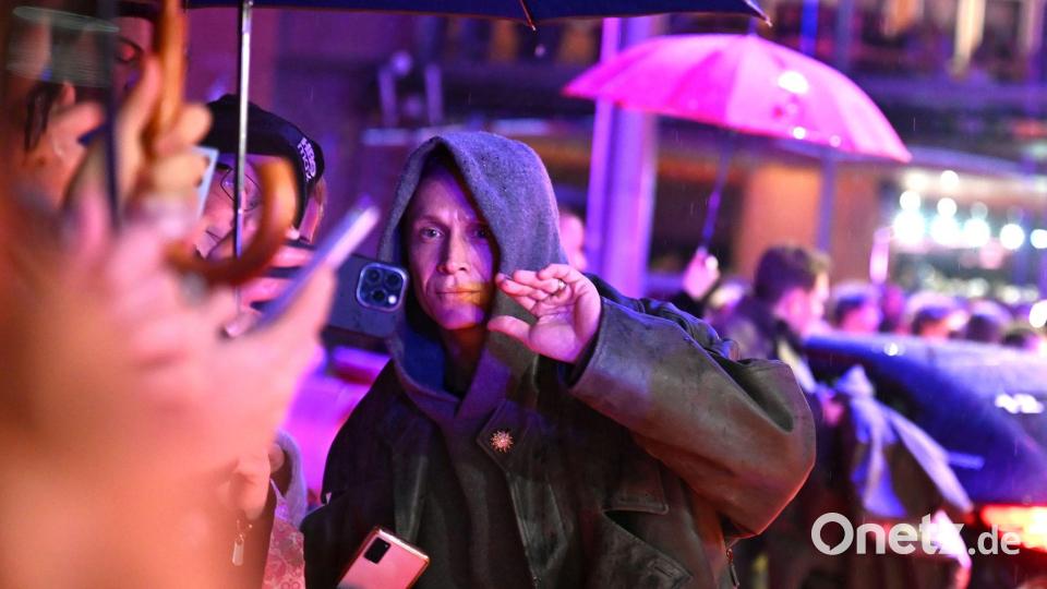 Matthias Schweighöfer auf dem roten Teppich - mit Fans und Regenschirmen. Bild: Elisa Schu/dpa