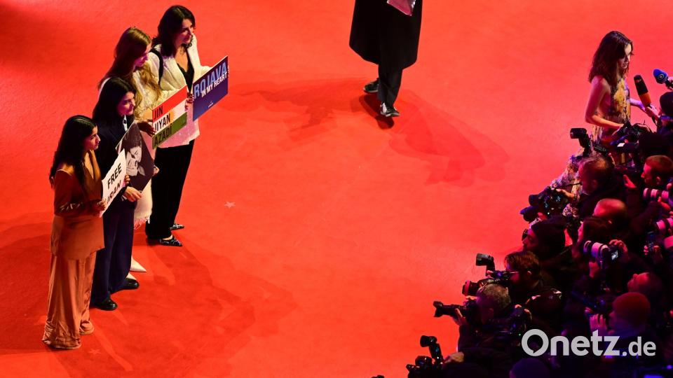 Gäste, darunter die deutsch-iranische Schauspielerin Jasmin Tabatabai (2. v. l.), halten Protestschilder hoch. Bild: Sebastian Christoph Gollnow/dpa