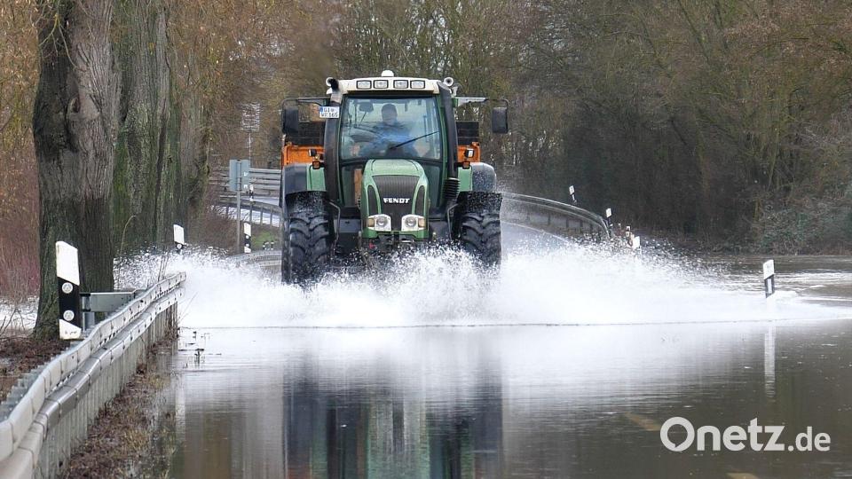 Ein Traktor fährt über die überschwemmte Lahnparkstraße in Heuchelheim. Bild: Thomas Naumann/dpa