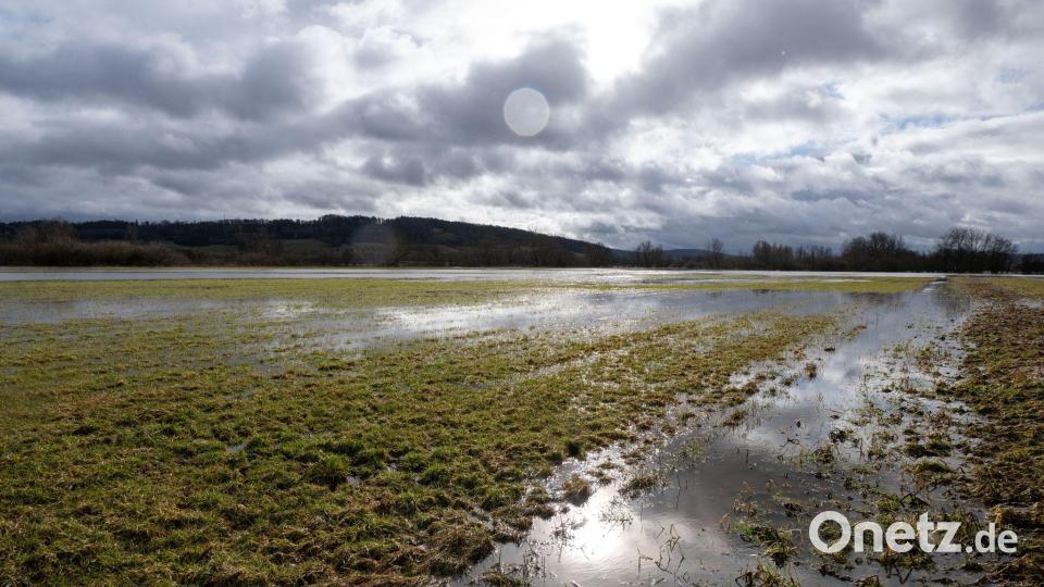 Ein Feld steht unter Wasser, nachdem es in Nordbayern viel geregnet hat und der Schnee weggetaut ist. Bild: Pia Bayer/dpa