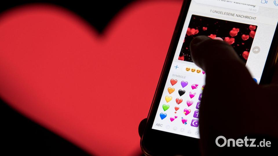 Hand aufs Handy - das rote Herz zählt zu den beliebtesten Emojis. (Archivbild) Bild: Fabian Sommer/dpa