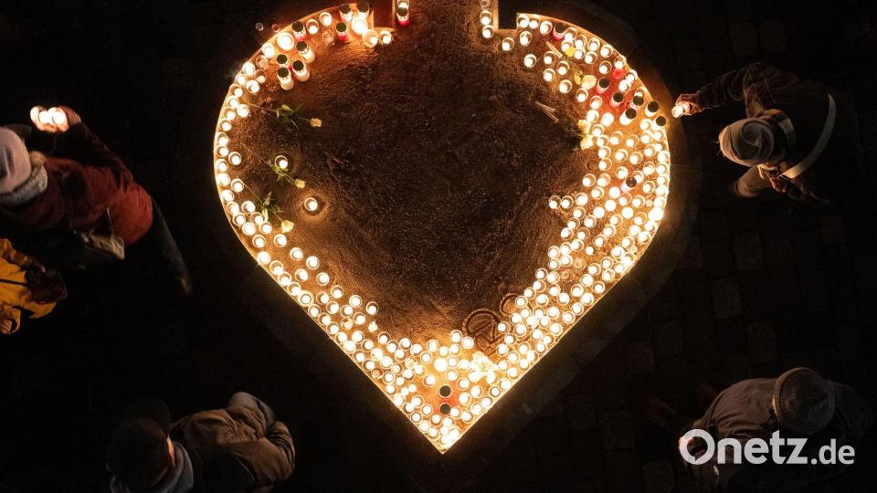 Passanten entzünden auf dem Neumarkt Kerzen am 81. Jahrestag der Zerstörung Dresdens. Bild: Sebastian Kahnert/dpa