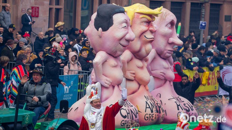 Ein Motivwagen mit nackten Trump, Putin und Xi Figuren beim Fastnachtsumzug in Frankfurt. Bild: Helmut Fricke/dpa