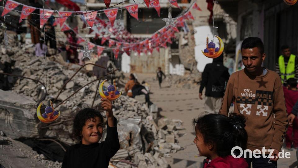 Palästinenser hängen Dekorationen neben den Trümmern zerstörter Häuser in Chan Junis auf, während sie sich auf den heiligen Monat Ramadan vorbereiten. Bild: Abdel Kareem Hana/AP/dpa