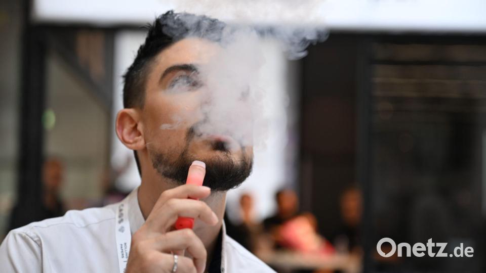 Ein Verkäufer einer E-Zigaretten-Firma nutzt bei der Dortmunder Messe Intertabac demonstrativ eine E-Zigarette. Der Verkauf dieser Produkte boomt. (Archivbild) Bild: Wolf von Dewitz/dpa