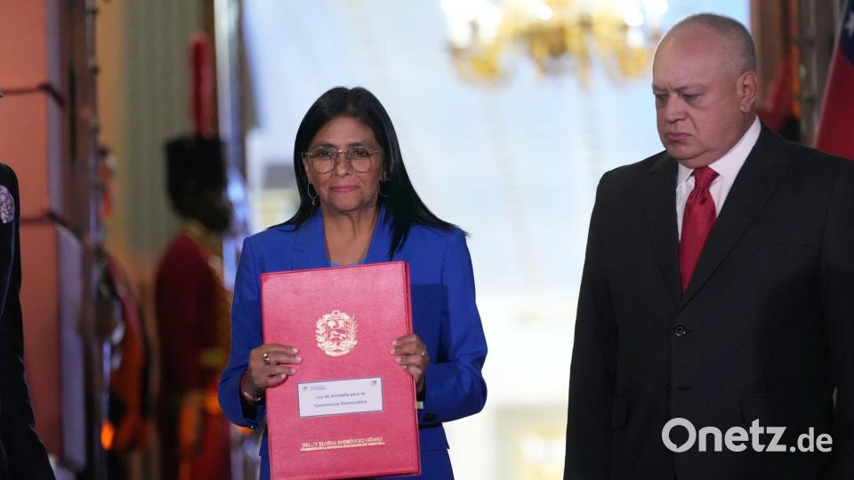 Die geschäftsführende Präsidentin Delcy Rodriguez hält ein verabschiedetes Amnestiegesetz hoch. Bild: Ariana Cubillos/AP/dpa