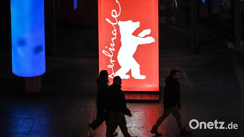 Passanten gehen am Abend der Preisverleihung an einem Berlinale-Plakat vorbei. Bild: Britta Pedersen/dpa