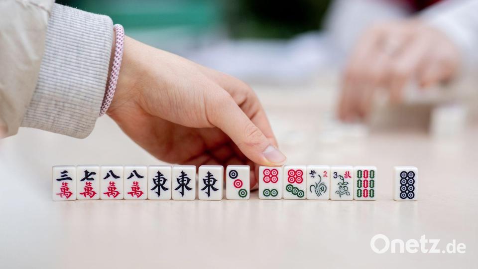 Besucher spielen bei dem chinesisches Neujahrsfest in den Gewächshäusern der Botanika in Bremen das chinesische Gesellschaftsspiel Mah-Jongg. Bild: Hauke-Christian Dittrich/dpa