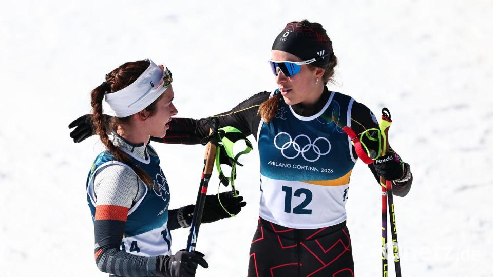 Darija Neprjajeva (l) nahm während des Olympia-Rennens versehentlich die Ski von Katharina Hennig Dotzler. Bild: Daniel Karmann/dpa