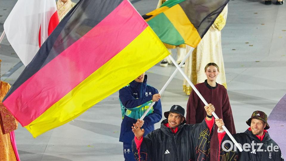 Tobias Wendl (l) und Tobias Arlt tragen die deutsche Fahne. Bild: Michael Kappeler/dpa
