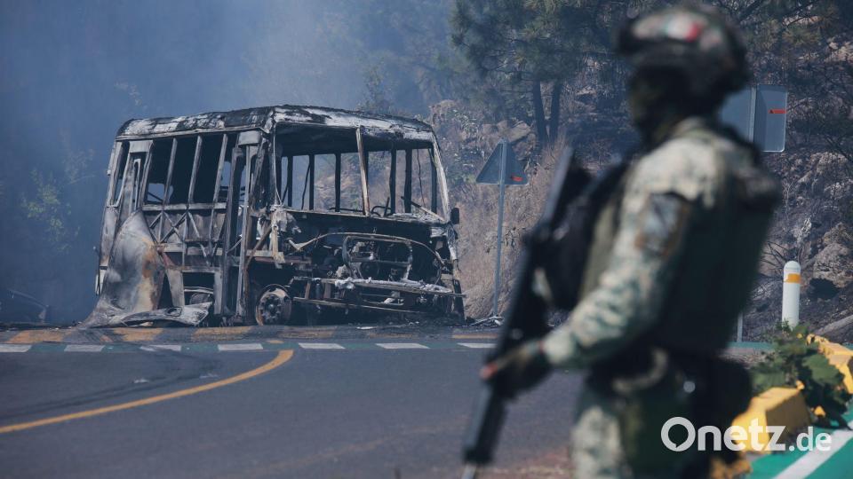 Ein Soldat steht neben einem ausgebrannten Bus, der nach dem Tod von Mexikos mächtigstem Drogenboss Nemesio Oseguera Cervantes, aka „El Mencho“, in Cointzio in Brand gesetzt wurde. Bild: Armando Solis/AP/dpa