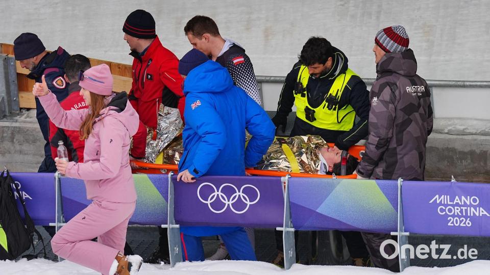 Jakob Mandlbauer wird nach einem Unfall vom medizinischen Betreuern und Sicherheitspersonal von der Eisbahn getragen. Bild: Michael Kappeler/dpa