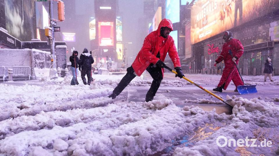 Arbeiter schaufelten Schnee auf dem Times Square in New York. Bild: Seth Wenig/AP/dpa