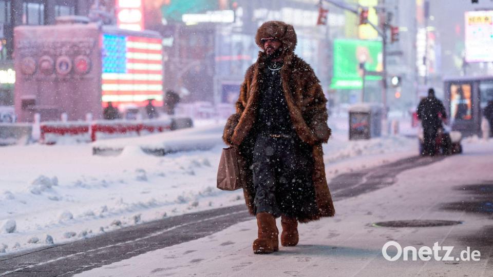 Ein Mann geht während eines Schneesturms über den Times Square in New York. Bild: Seth Wenig/AP/dpa