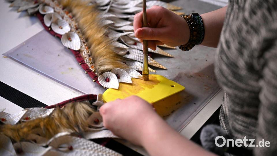 Mit Pinsel und goldener Farbe bemalt Toni ihr Kostüm. Bild: Jennifer Brückner/dpa