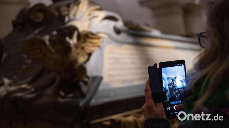 Eine Frau fotografiert am Tag der Offenen Tür anlässlich der Wiedereröffnung der Hohenzollerngruft im Berliner Dom einen Sarg. Bild: Christophe Gateau/dpa