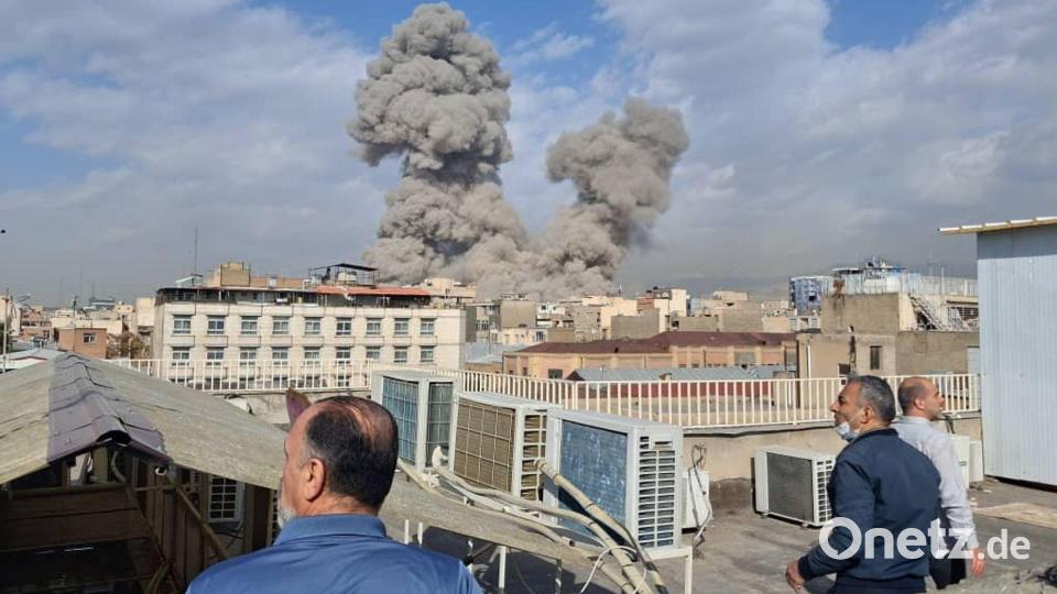 Israel greift den Iran an - Menschen beobachten Rauch nach einer Explosion in Teheran. Bild: Uncredited/AP/dpa