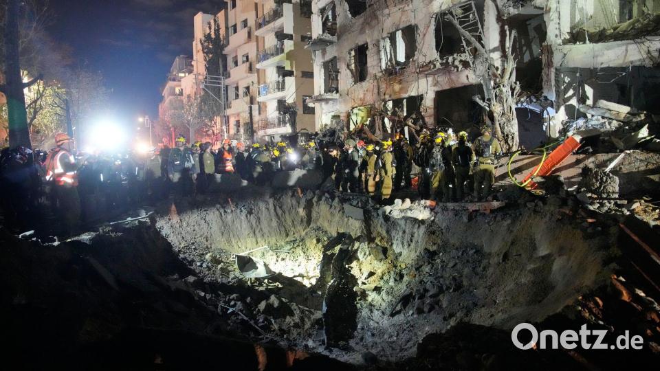 Beamte des israelischen Heimatfrontkommandos durchsuchen die Trümmer eines beschädigten Wohnhauses. Bild: Ohad Zwigenberg/AP/dpa