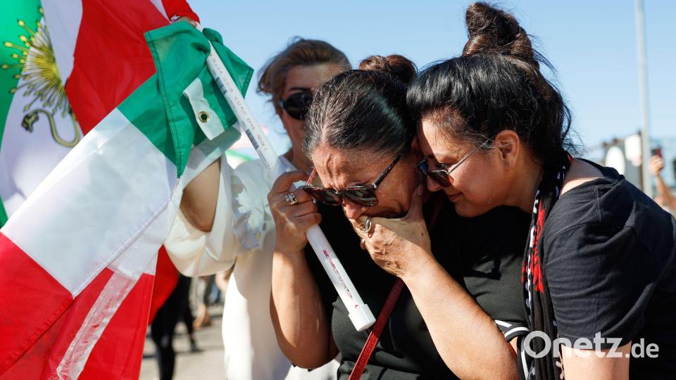 Zwei Frauen umarmen sich während einer Demonstration. Bild: Caroline Brehman/AP/dpa