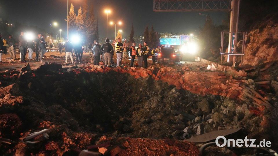 Israelische Sicherheitskräfte inspizieren eine beschädigte Straße, nachdem eine aus dem Iran abgefeuerte Rakete in Jerusalem eingeschlagen ist. Bild: Mahmoud Illean/AP/dpa